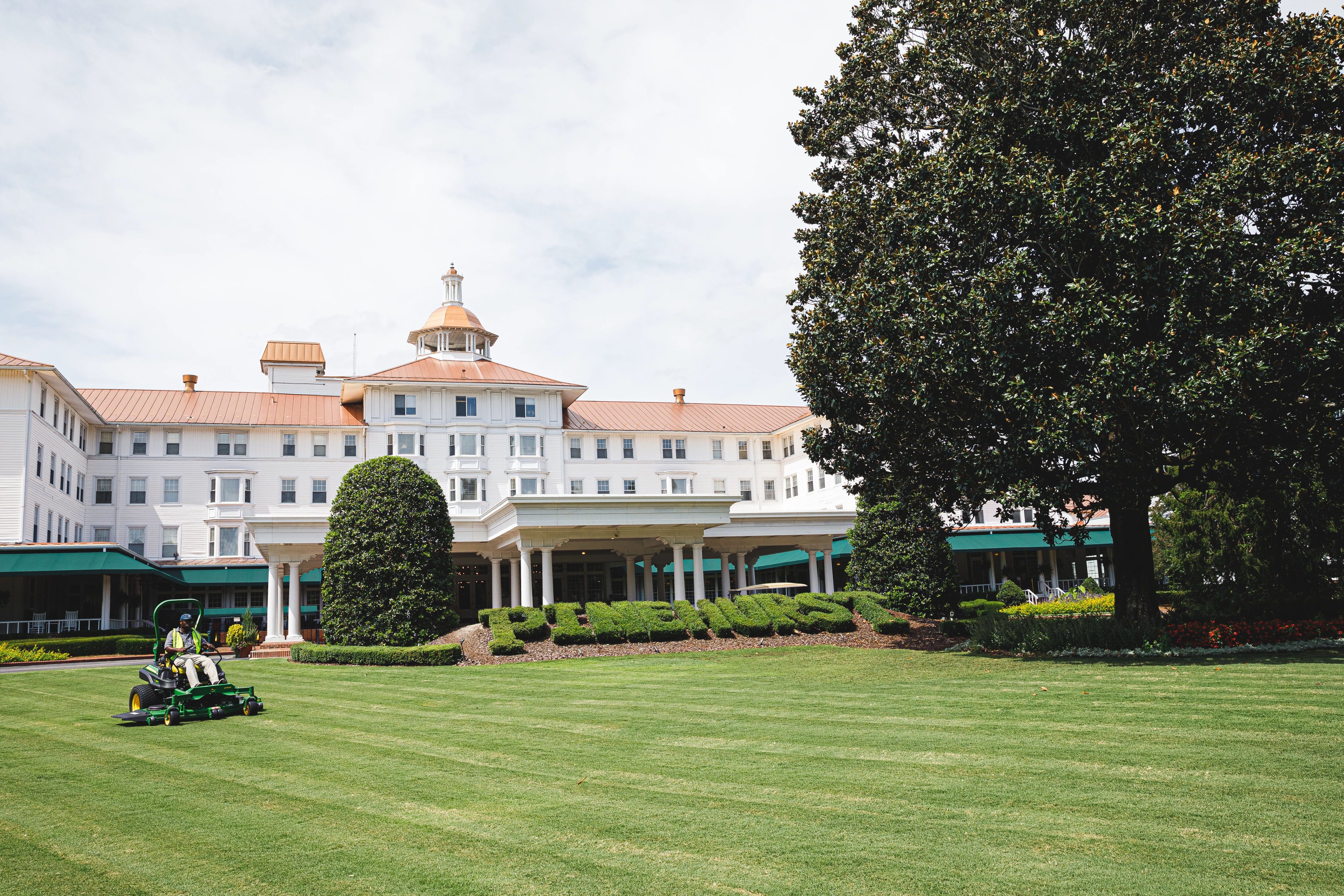 Pinehurst Resort, North Carolina, September 2021, grounds maintenance personnel mowing the lawn in front of the resort clubhouse