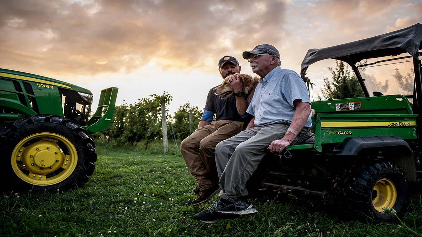 image of 2 men and dog sitting on back of gator