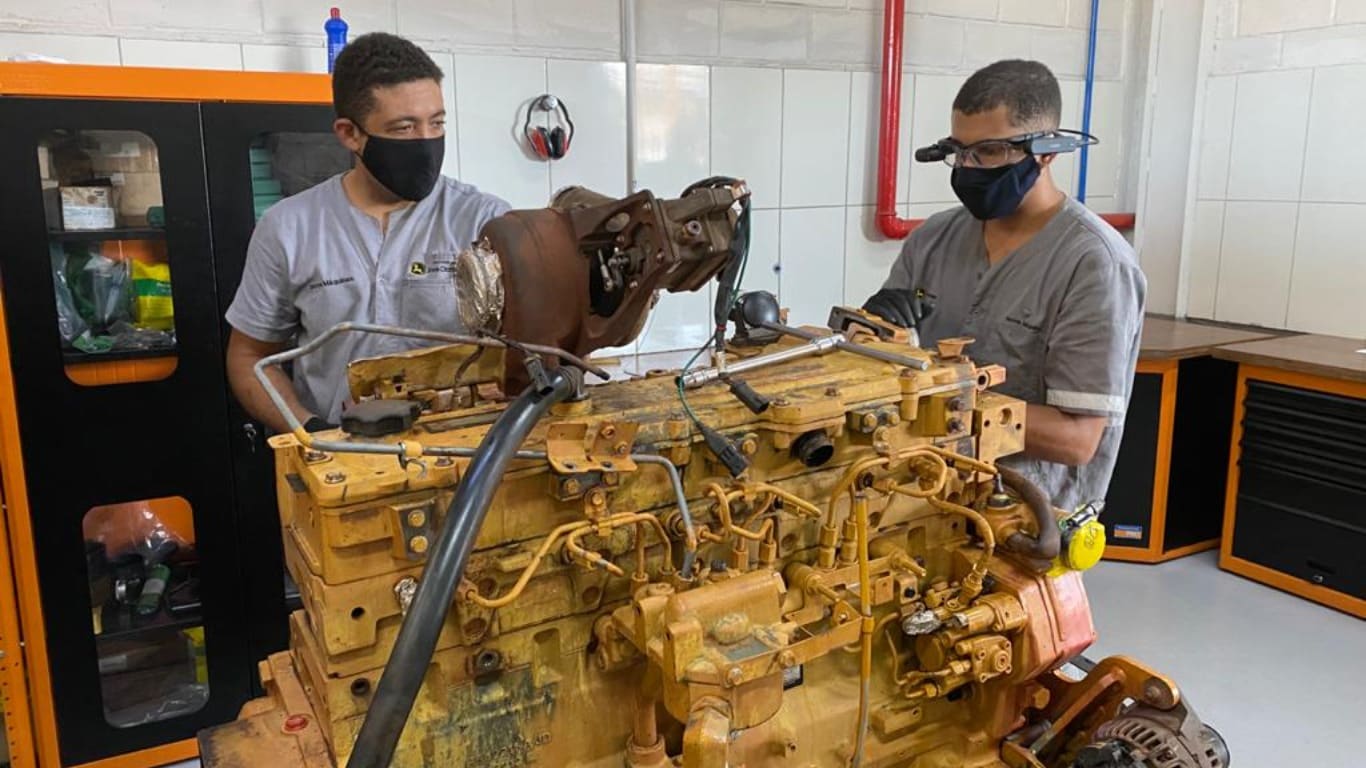 Two Inova technicians using John Deere Smart Glasses technology to assess the condition of an industrial engine