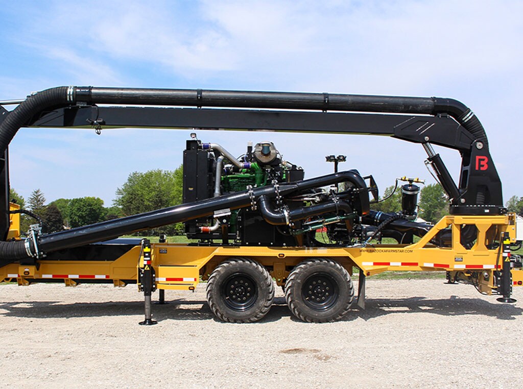 A side view of Bazooka Farmstar's Outlaw Boom Trailer manure pump on a farm.