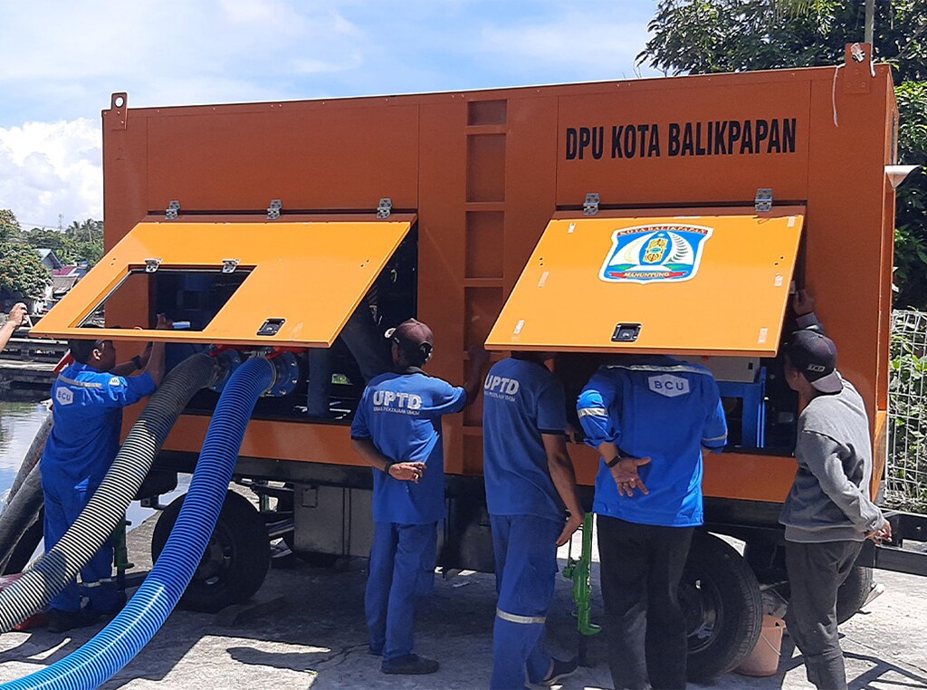 A BCU water pump at work in Indonesia with 6 workers standing by.