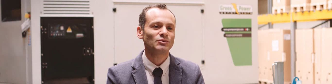 A portrait of Giovanni Massaro in front of generator set