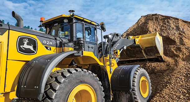 John&nbsp;Deere 824 X-Tier Wheel Loader, powered by a John&nbsp;Deere JD9 engine, emptying dirt onto a pile. 