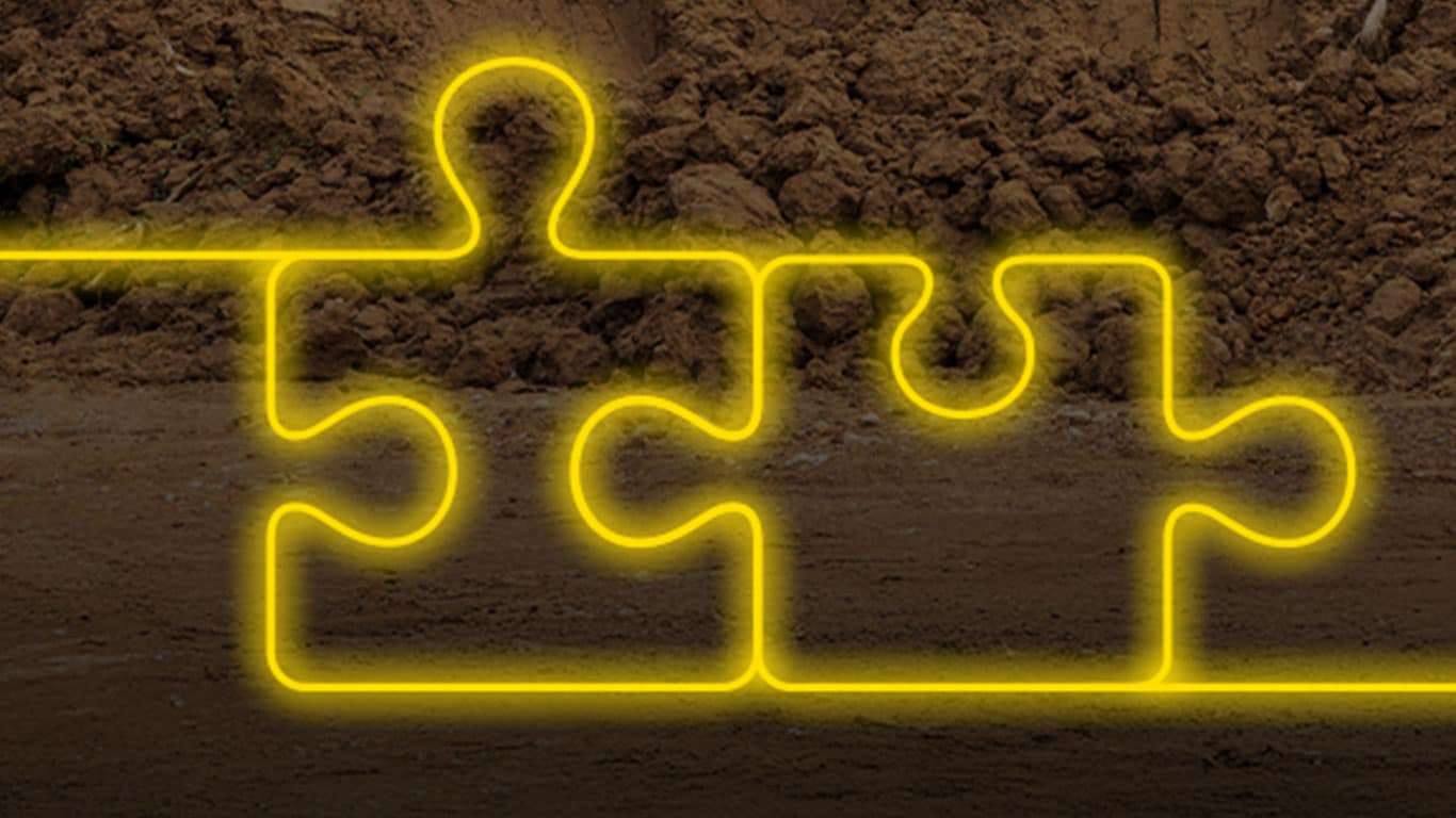 Illustration of two gold neon puzzle pieces overlaid on rocky terrain. 