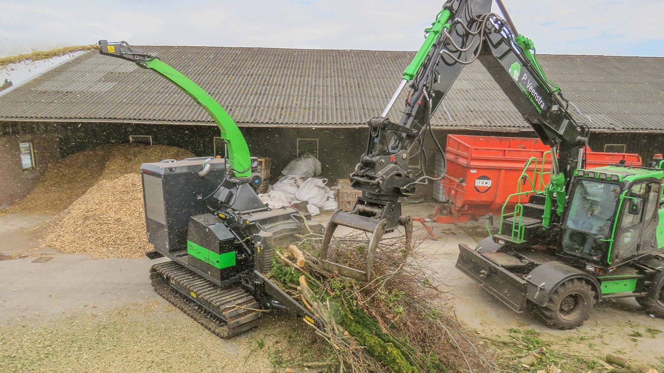 Ufkes Greentec's 962 Venturi tracked side loader cutting branches and discharging woodchips on a worksite