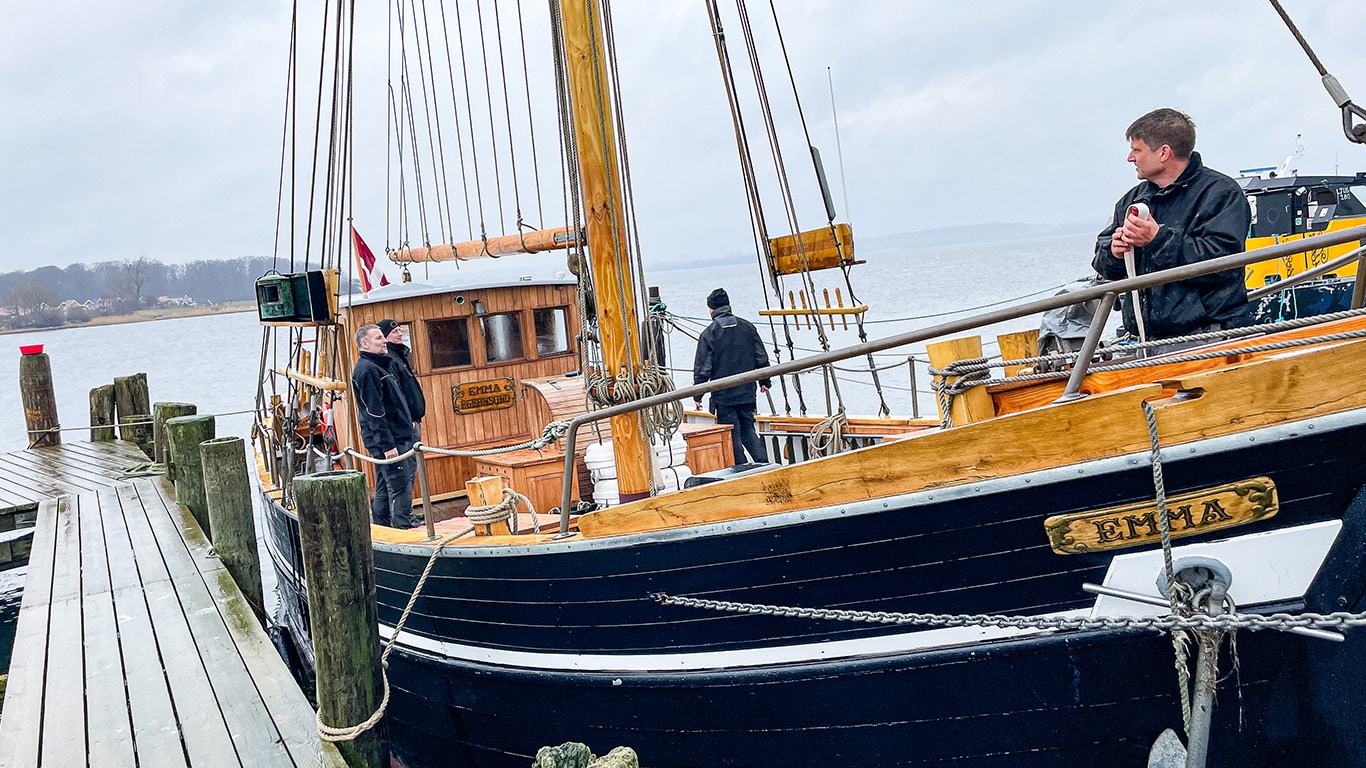 Wooden sailing ship Emma at the dock preparing to set sail with 4 crew members on board