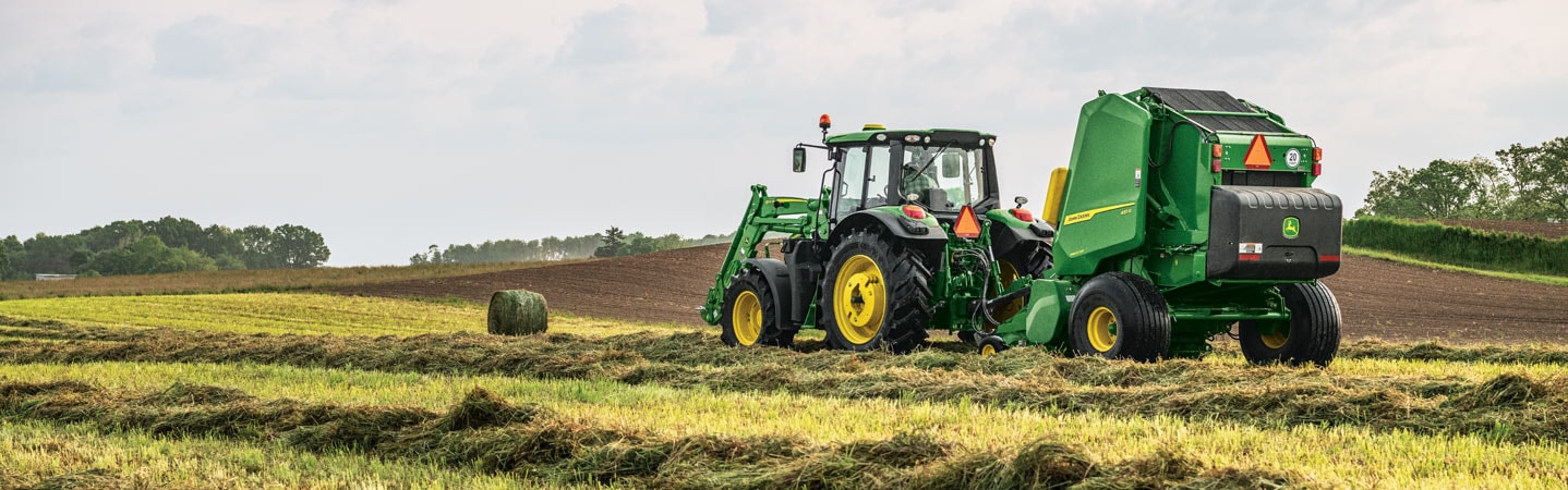 6120M Tractor pulling 451R Round Baler baling hay