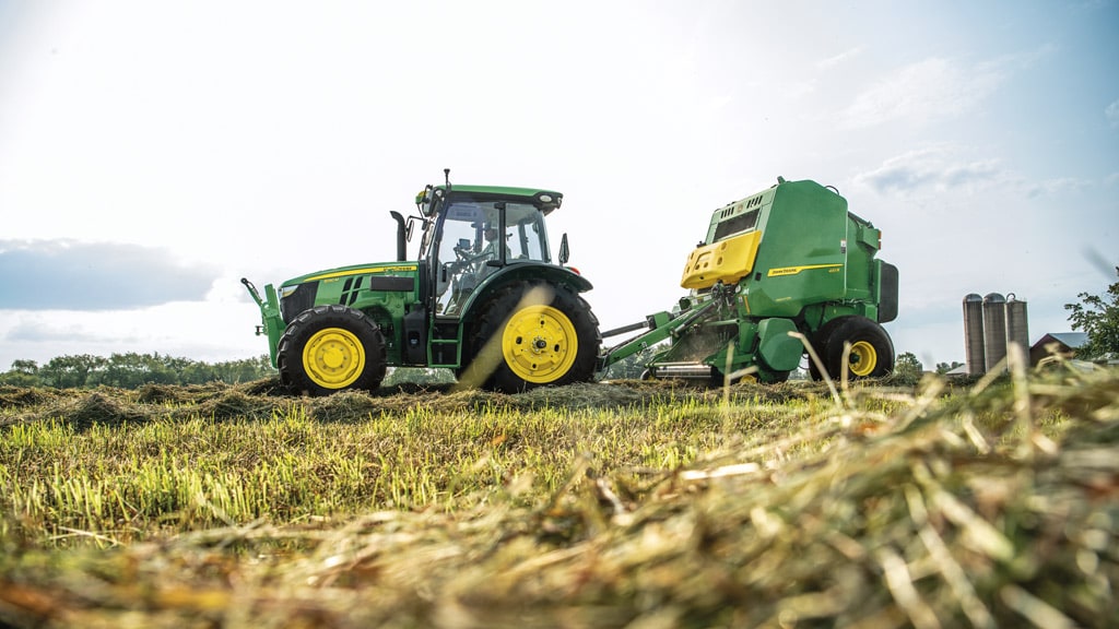 5 Series Tractor pulling a 1 series round baler in field