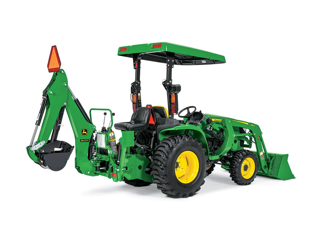 A green backhoe attached to the back of a green tractor also equipped with a front loader.