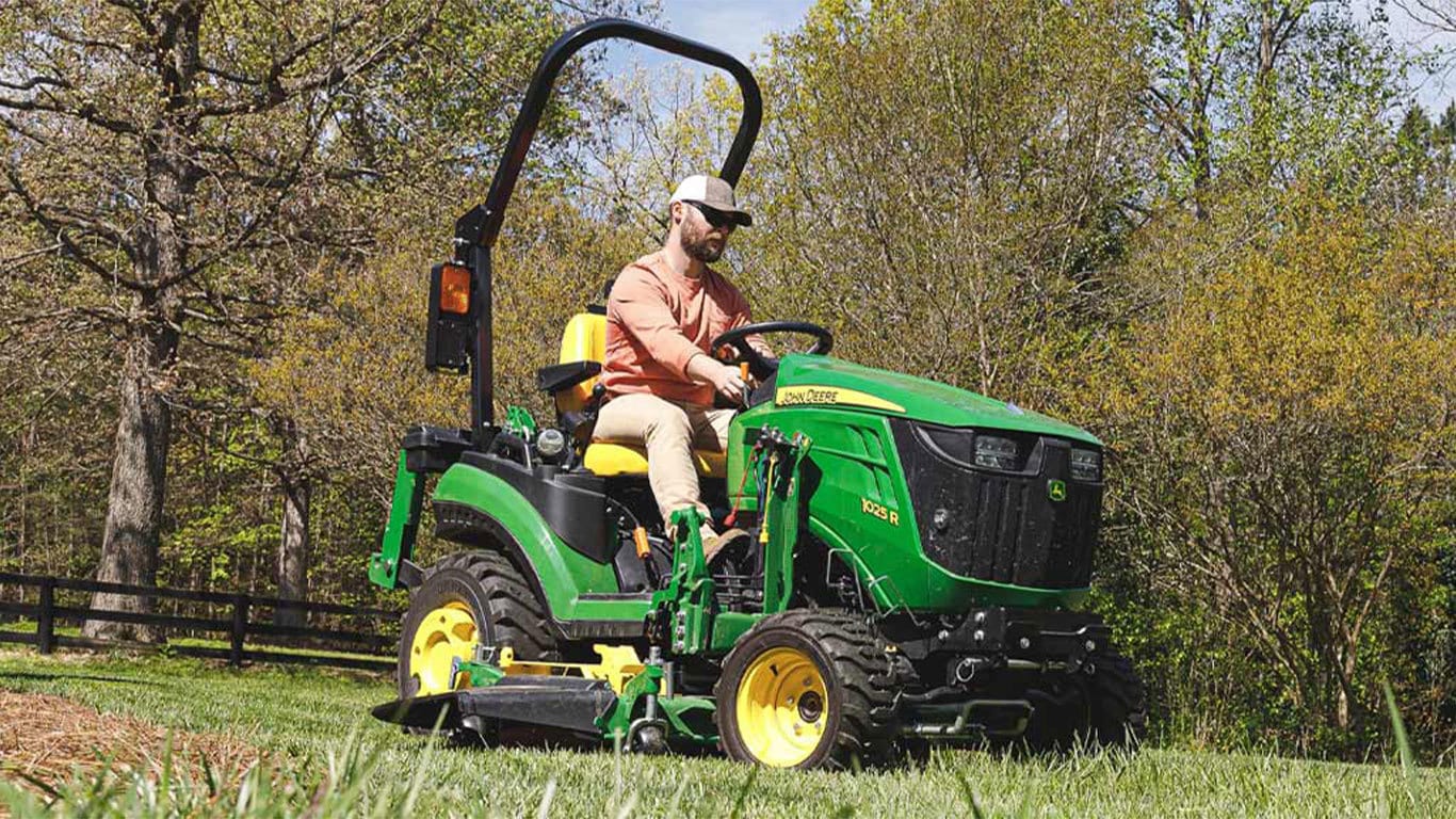  2024 Model 1025R with LED head lamps mowing acreage with mulcher attachment 