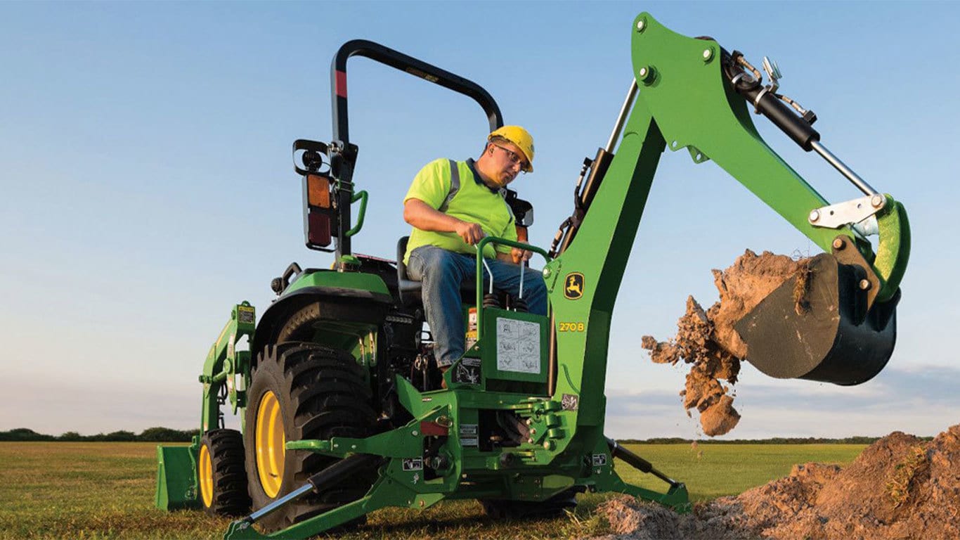 Man scooping mud with the 2038r tractor