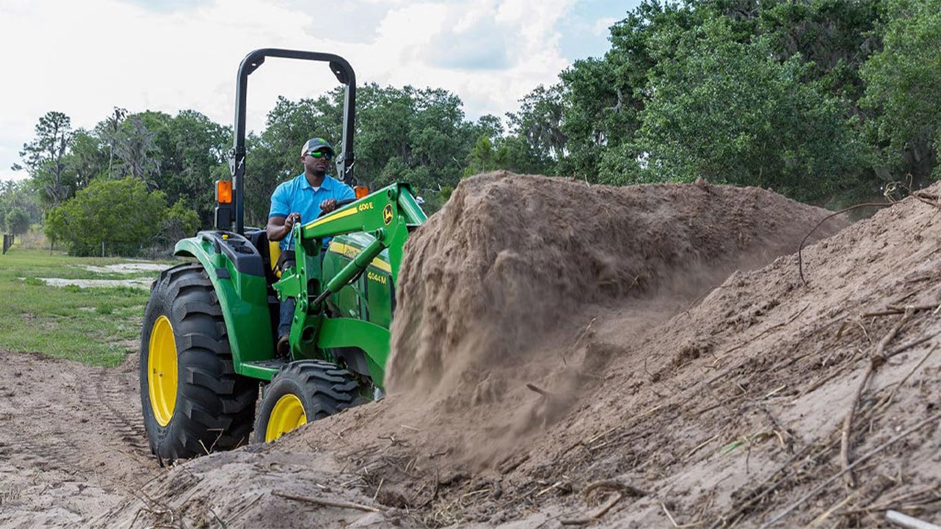 Man on 4044m tractor shoveling dirt