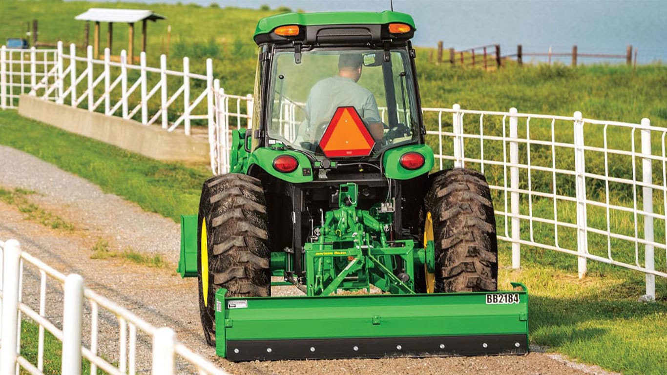 Man driving a 4044r tractor down a country road