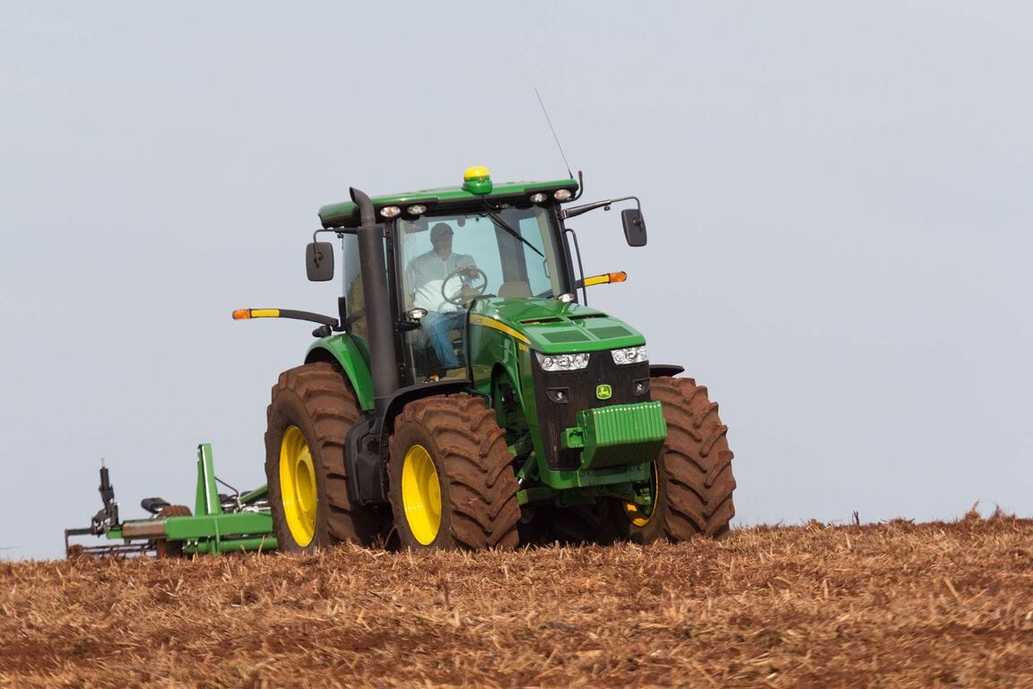 Tractor John Deere 8250R haciendo preparación de suelo en campo de caña.