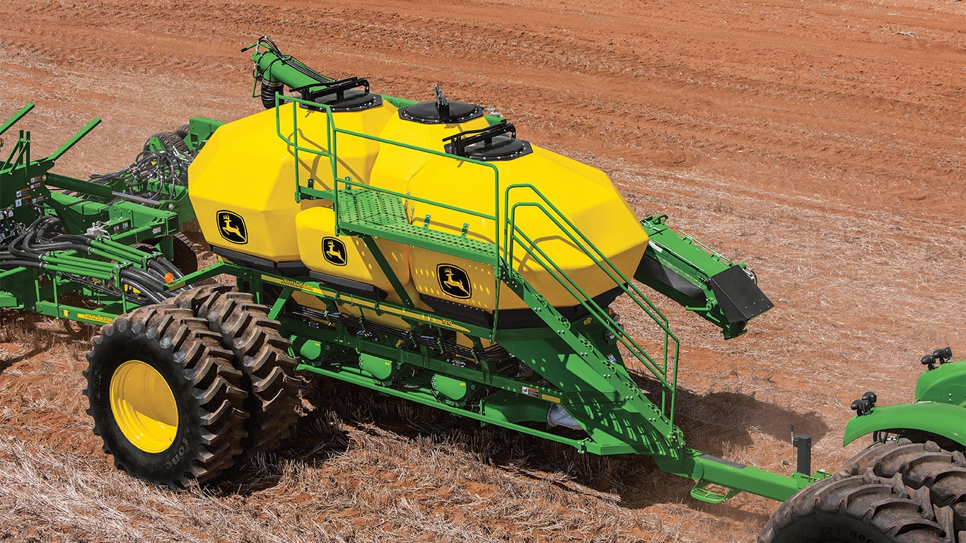 field shot of a 9510R tractor pulling a 1910 air commodity cart