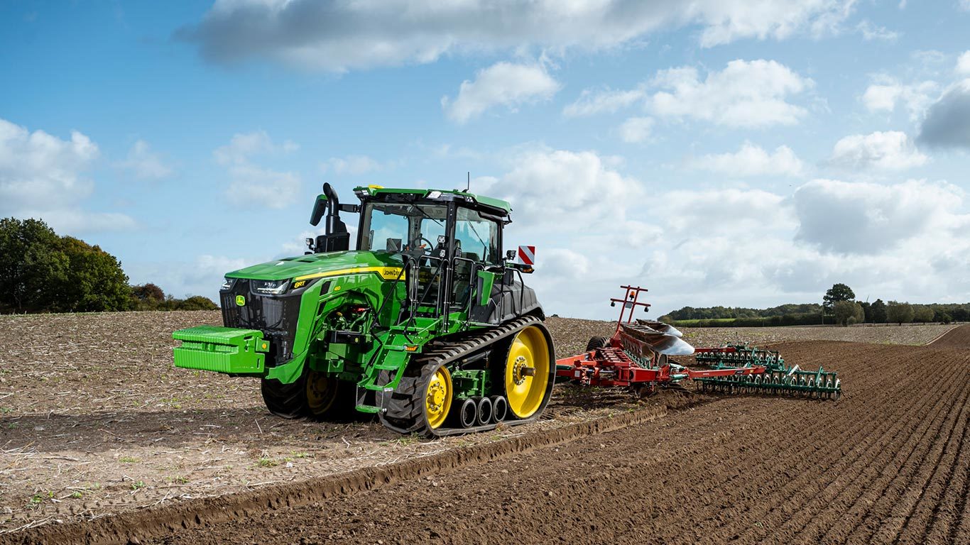 Foto de campo Trator grande John Deere serie 8RT, acoplado con plantadeira