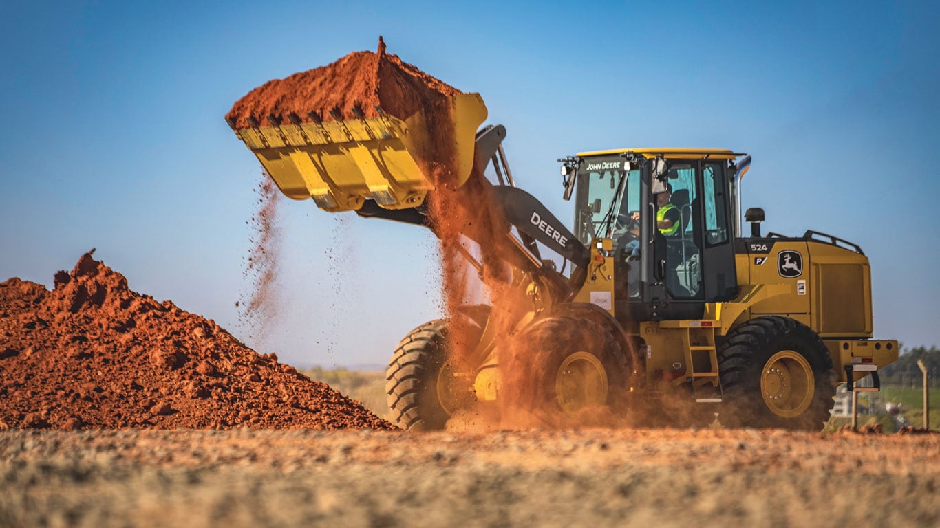 Cargadora de ruedas 524 P-Tier que utiliza cucharón para recoger y mover tierra en el lugar de trabajo.