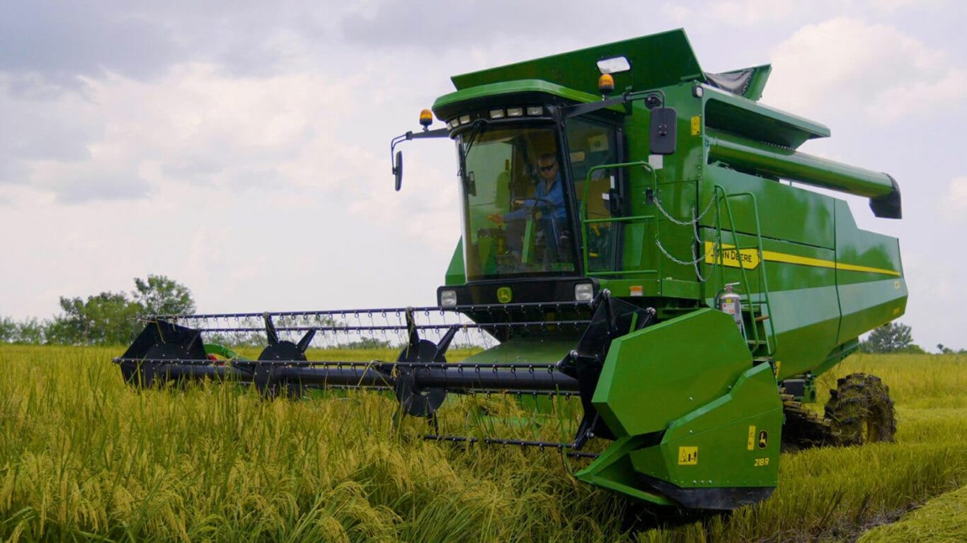 Plataforma 218R, acoplada a una cosechadora John Deere, en el campo.