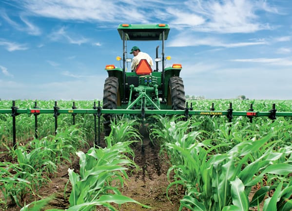 Cultivador MX 10 en el campo con tractor John Deere.