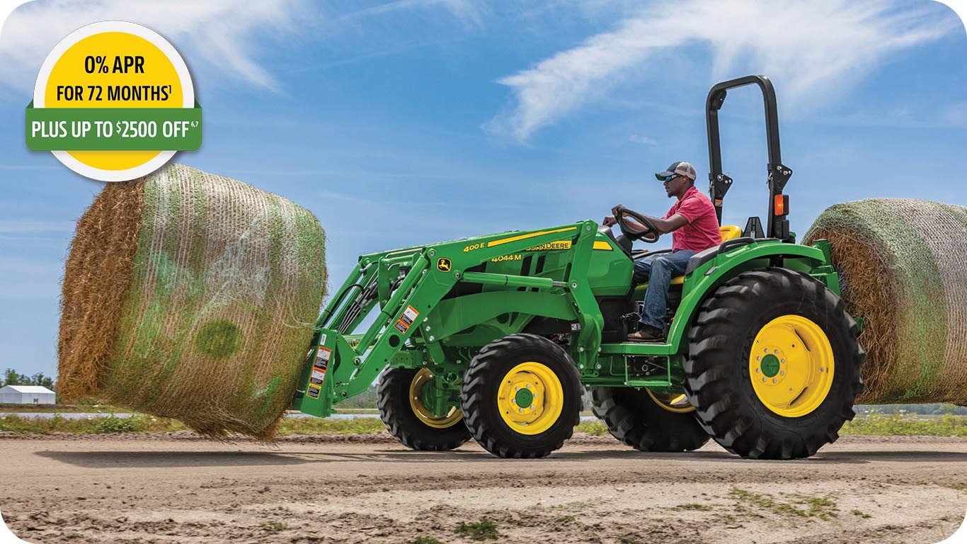 0% APR for 72 months, plus up to 2500 dollars off advertisement, showing a man in the seat of a John Deere 4044M tractor with bay spear moving bale of hay.