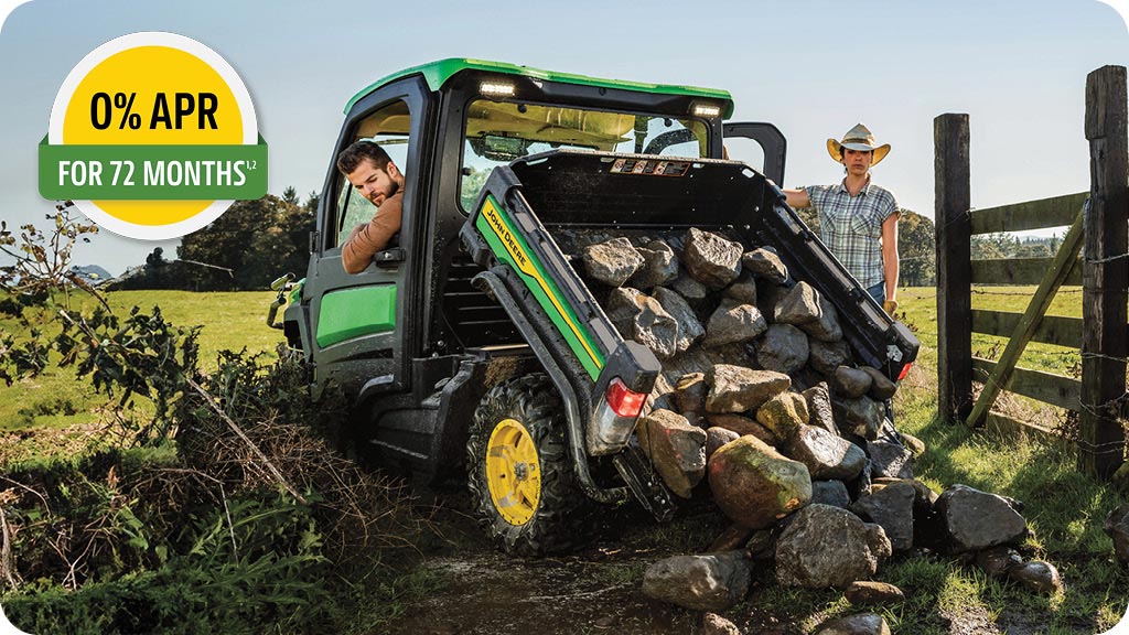 0% APR for 72 months advertisement showing a man in a John Deere XUV835R Series Gator utility vehicle unloading large rocks from cargo box.