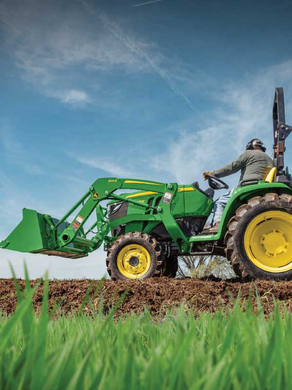 Man on tractor in the field with big blue sky