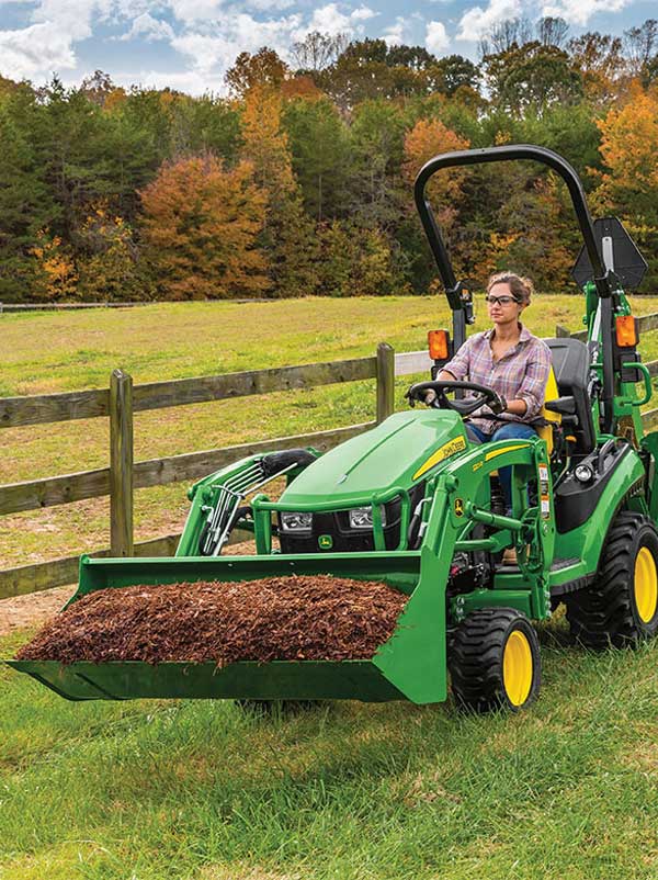 woman on tractor hauling soil