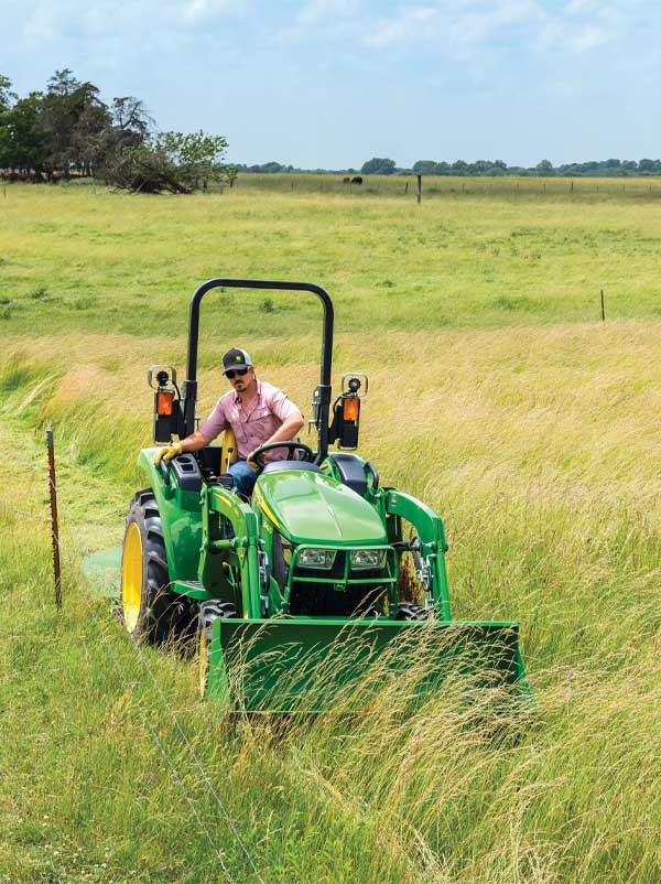 Man on tractor in tall grass