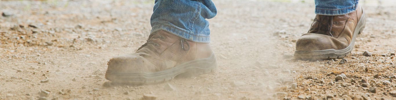 Boots walking across the land sending up dust