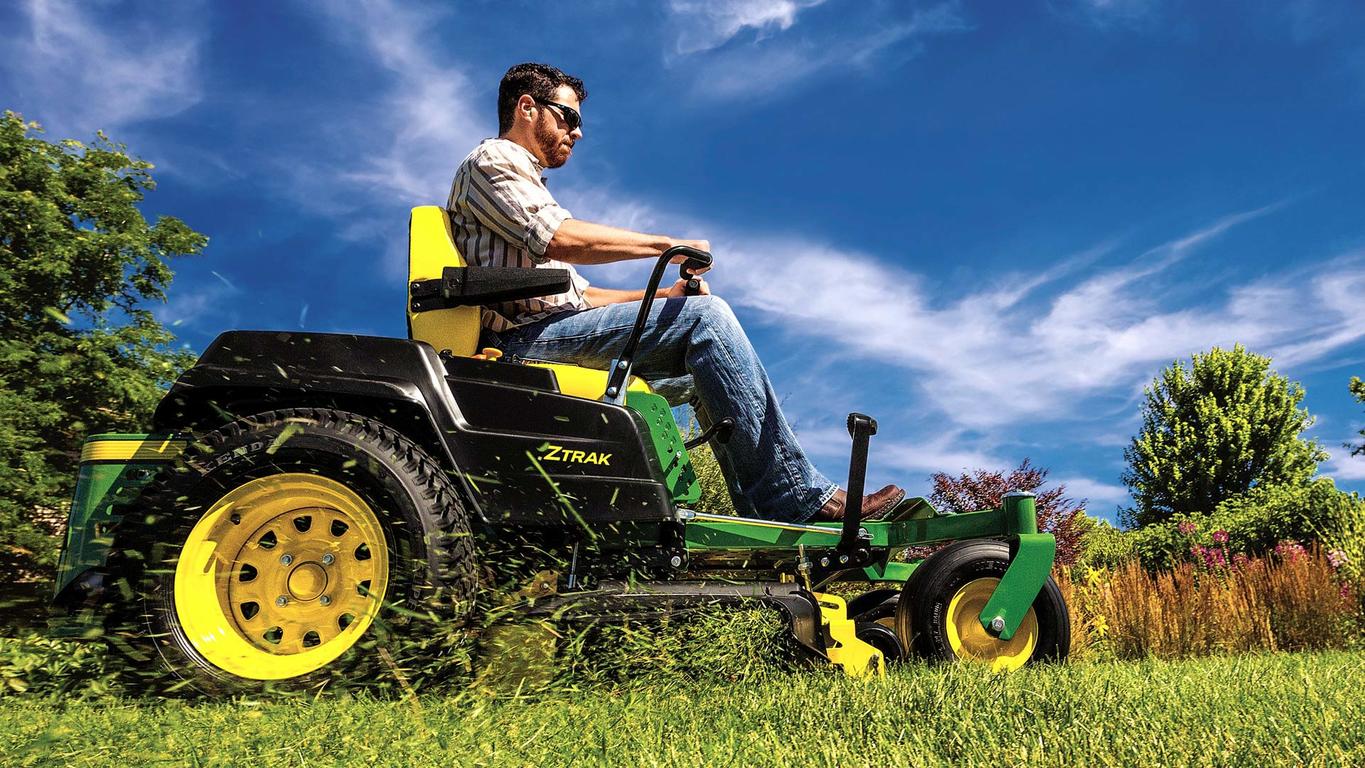 man driving ztrack through grass
