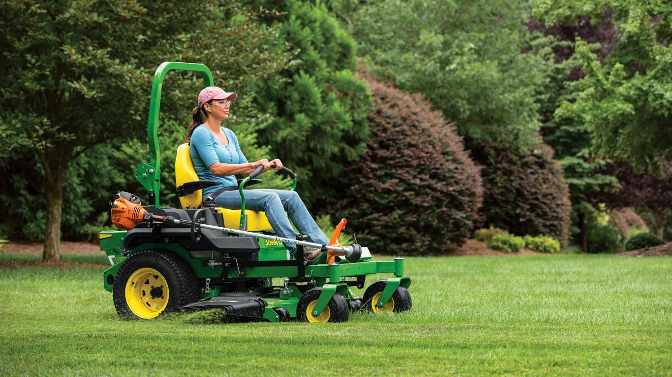 woman cutting grass with a John Deere riding lawn mower