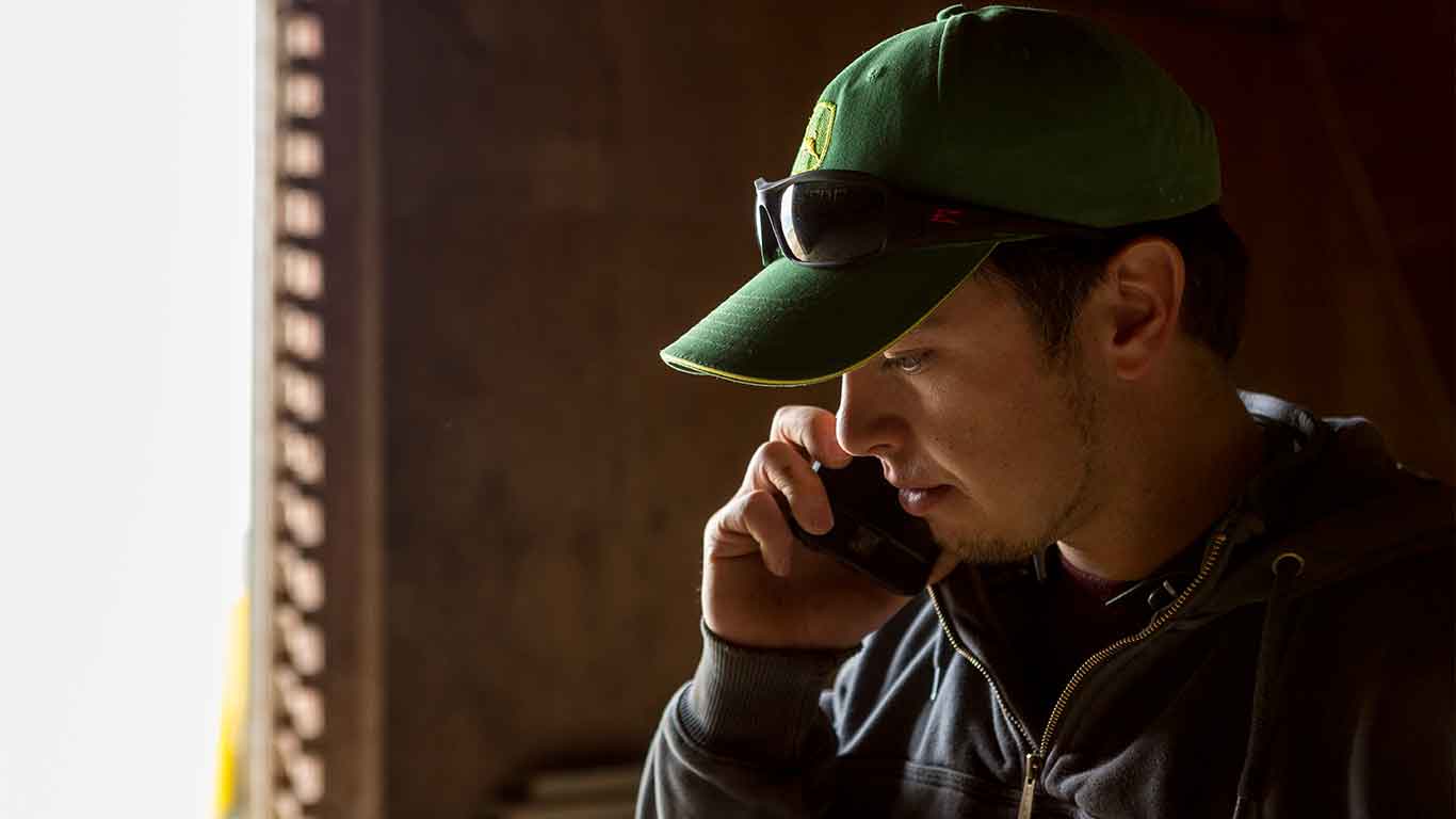  Man using his cell phone in a barn.