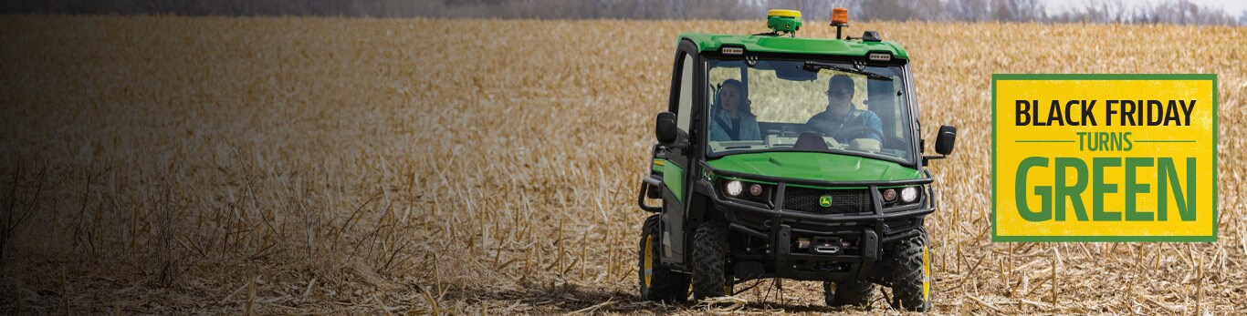 People riding on a gator through a field 