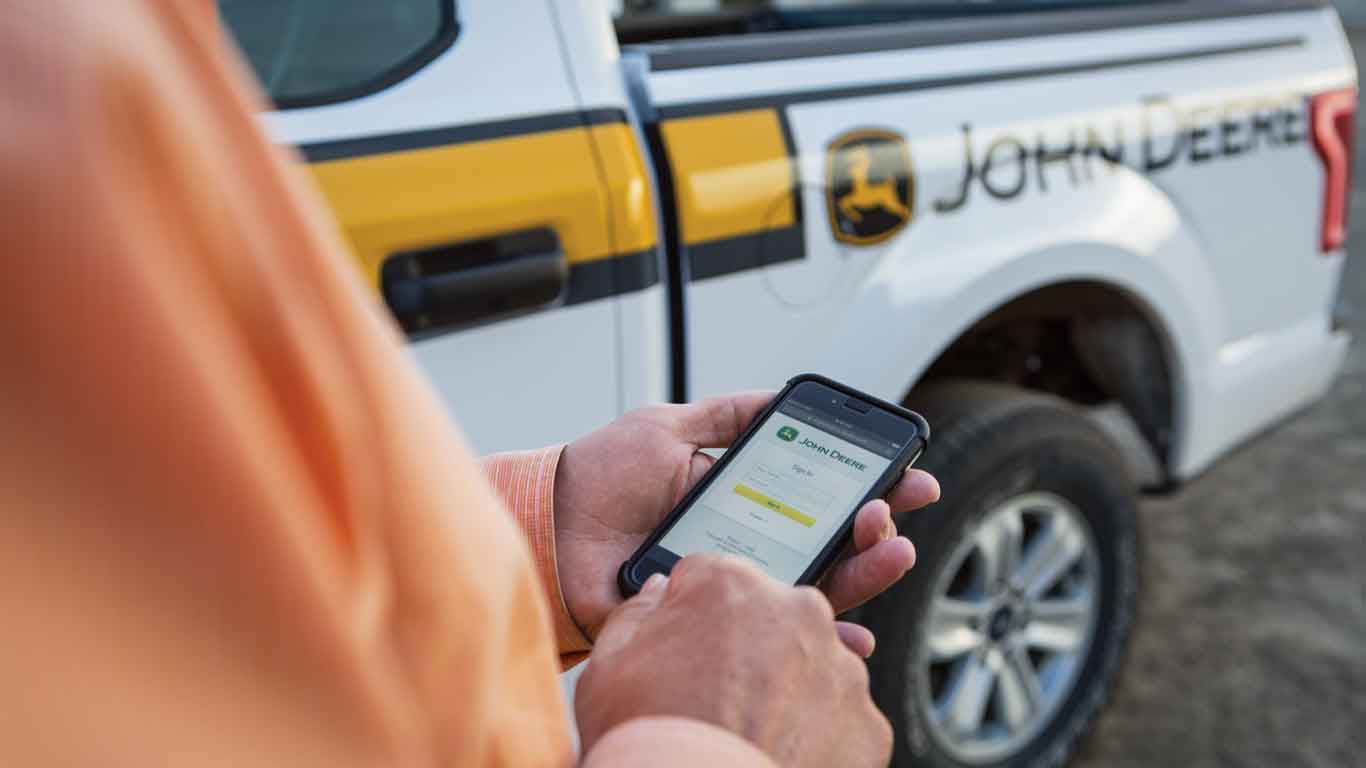  Man using his phone standing next to his pickup truck