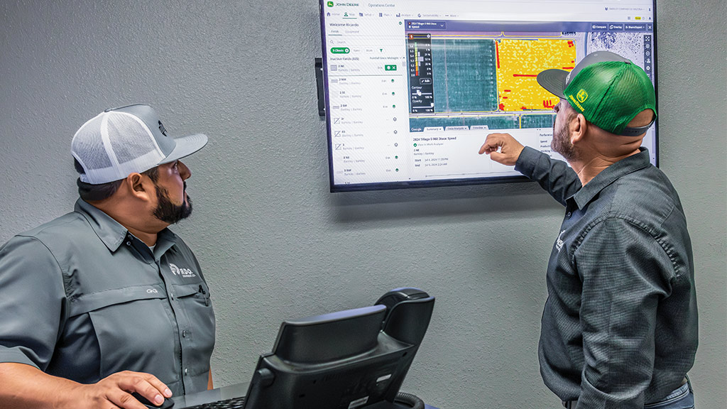 Two people reviewing data on a large screen in a tech workspace.