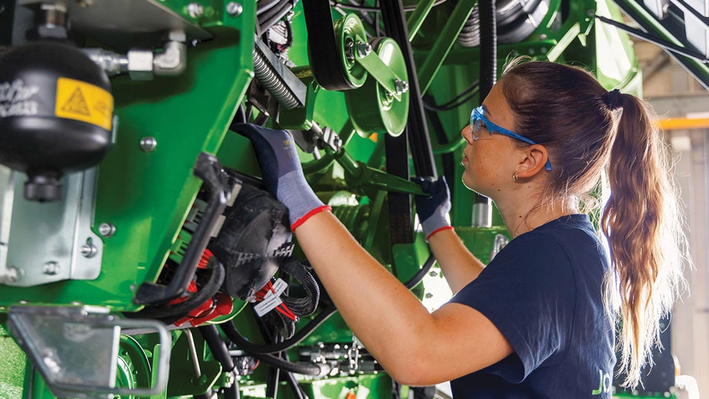 John Deere Technician inspecting a combine.