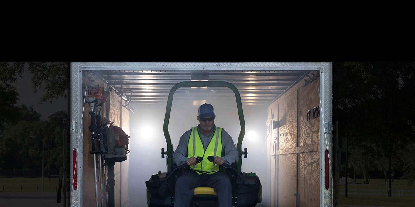  Backlit teaser of the new commercial mower being revealed at this year's expo exiting a trailer.