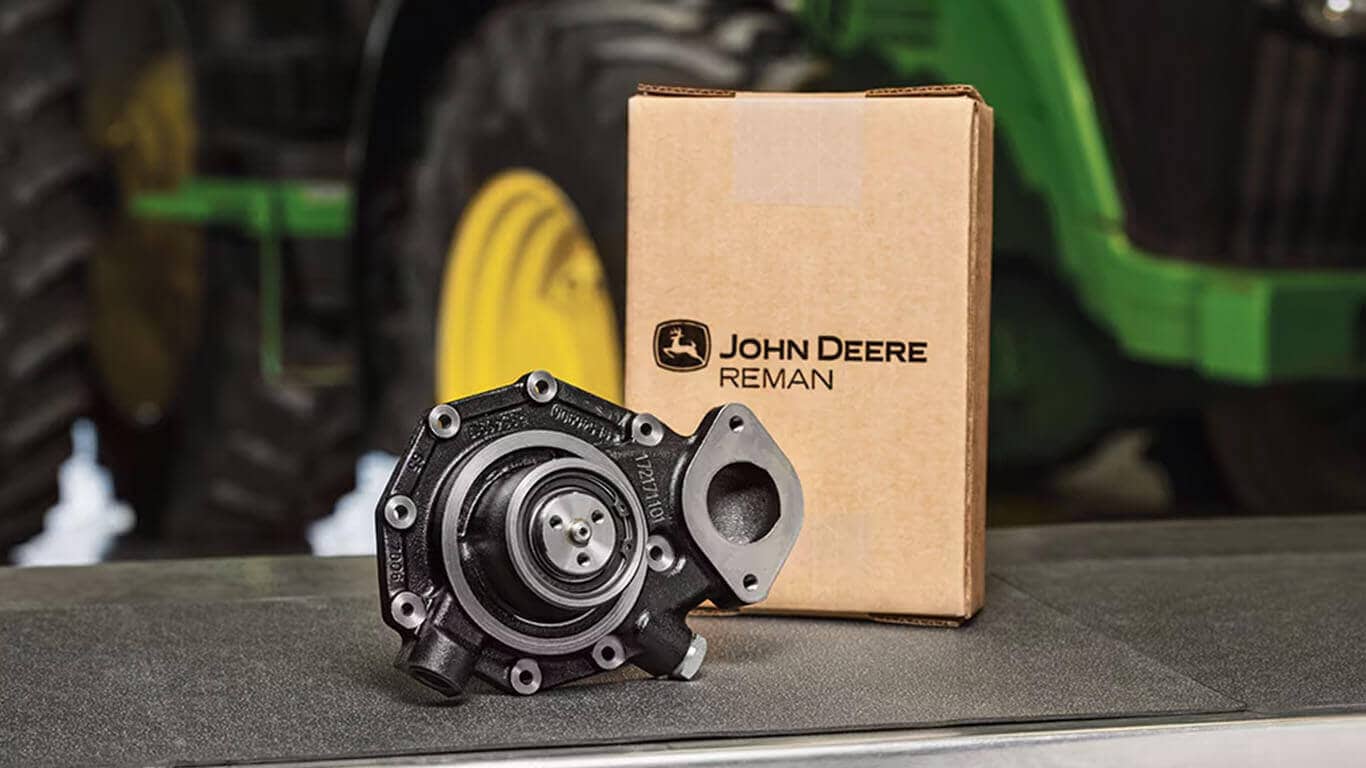 Photo of a remanufactured John Deere part next to a branded box on a workbench.