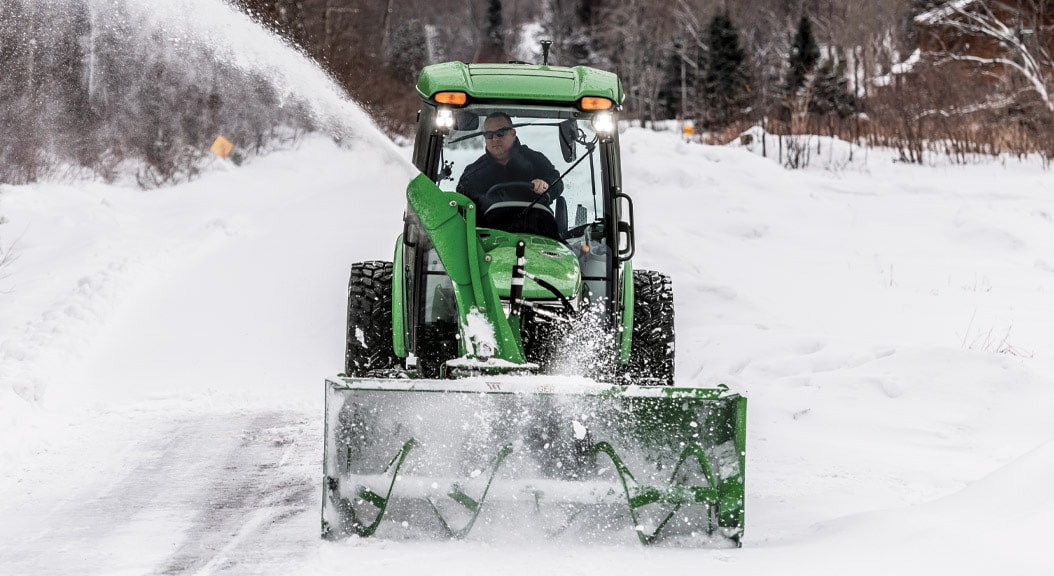 person blowing snow with 4075R Compact Tractor equipped with snow blower