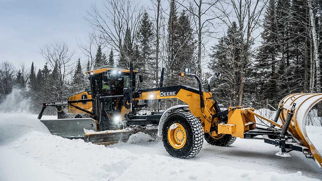 Person clearing road from snow using a Motor Grader