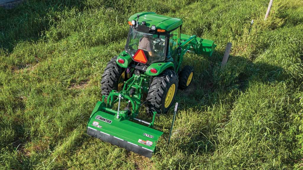John Deere 4075R Compact Tractor with a Frontier FL1169 Flail Mower attached mowing in a field near a fence line.