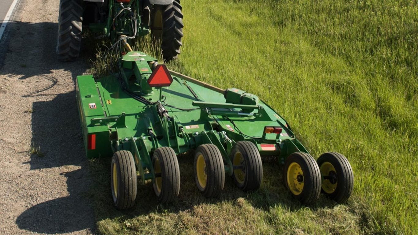 Tractor pulling a FC10R rotary cutter mowing a roadside