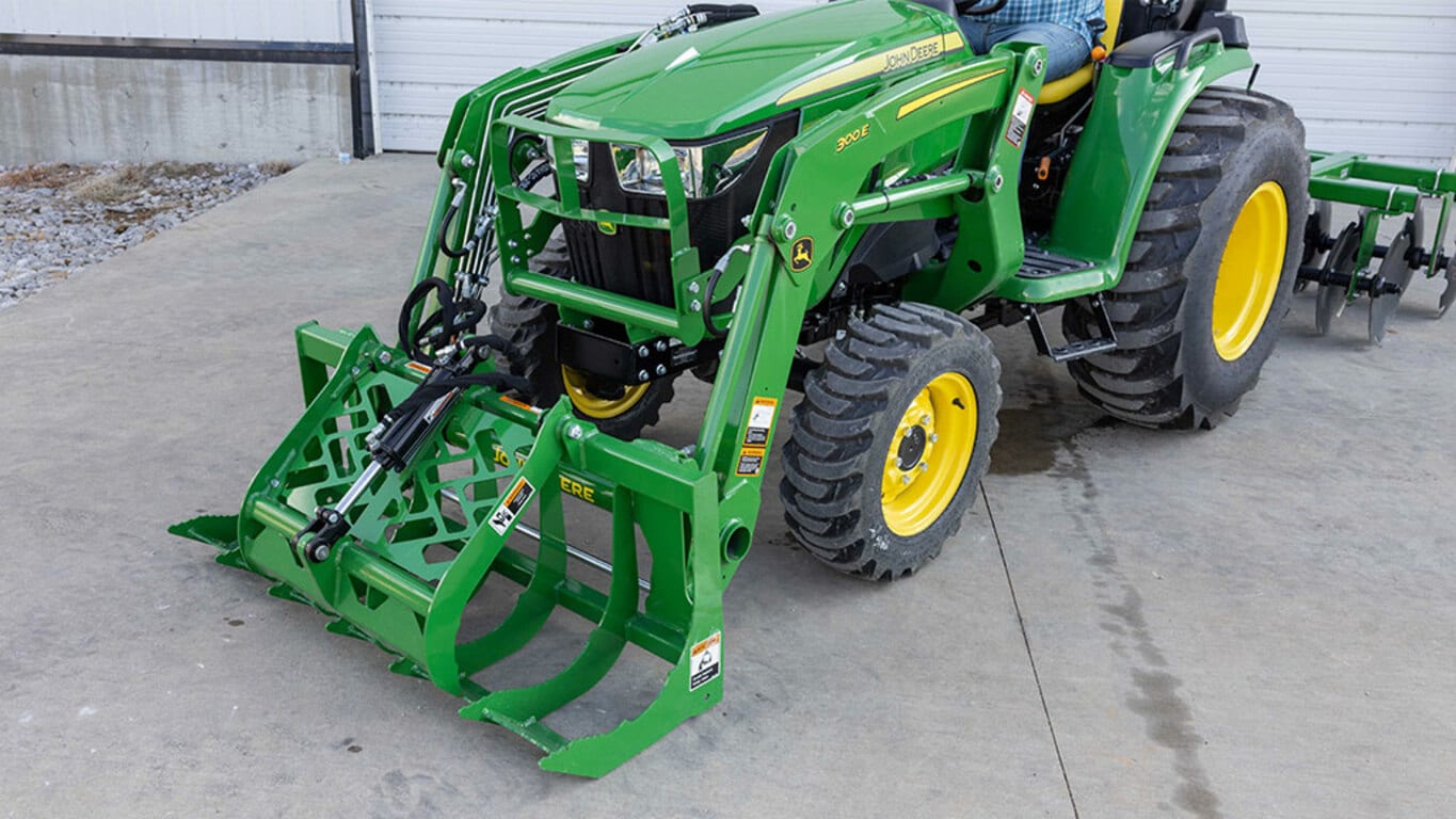 AV20 Root Grapple on a 300E Loader attached to a compact utility tractor