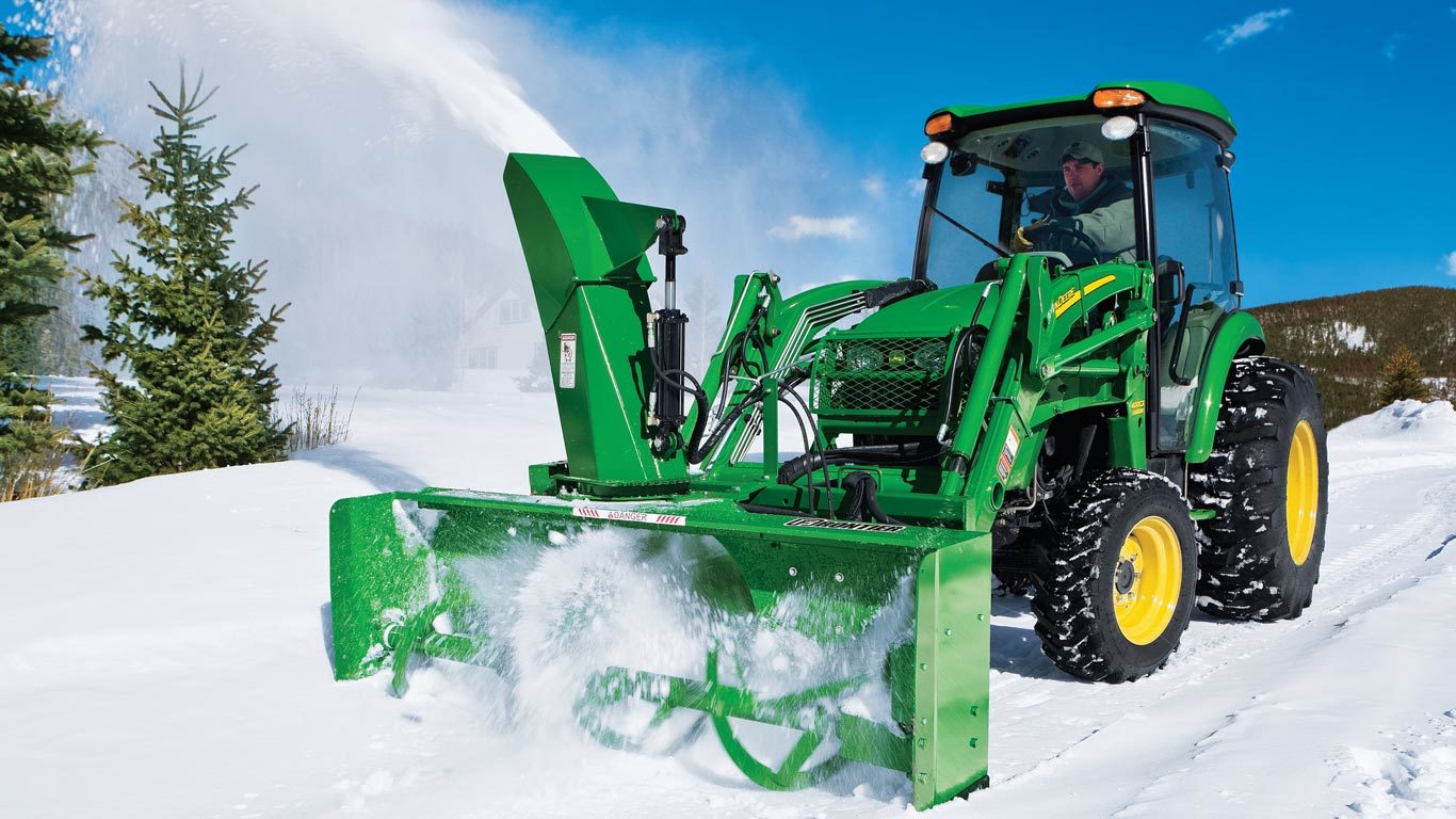 field image of a sb21 series loader mount snow blower on a tractor in the snow