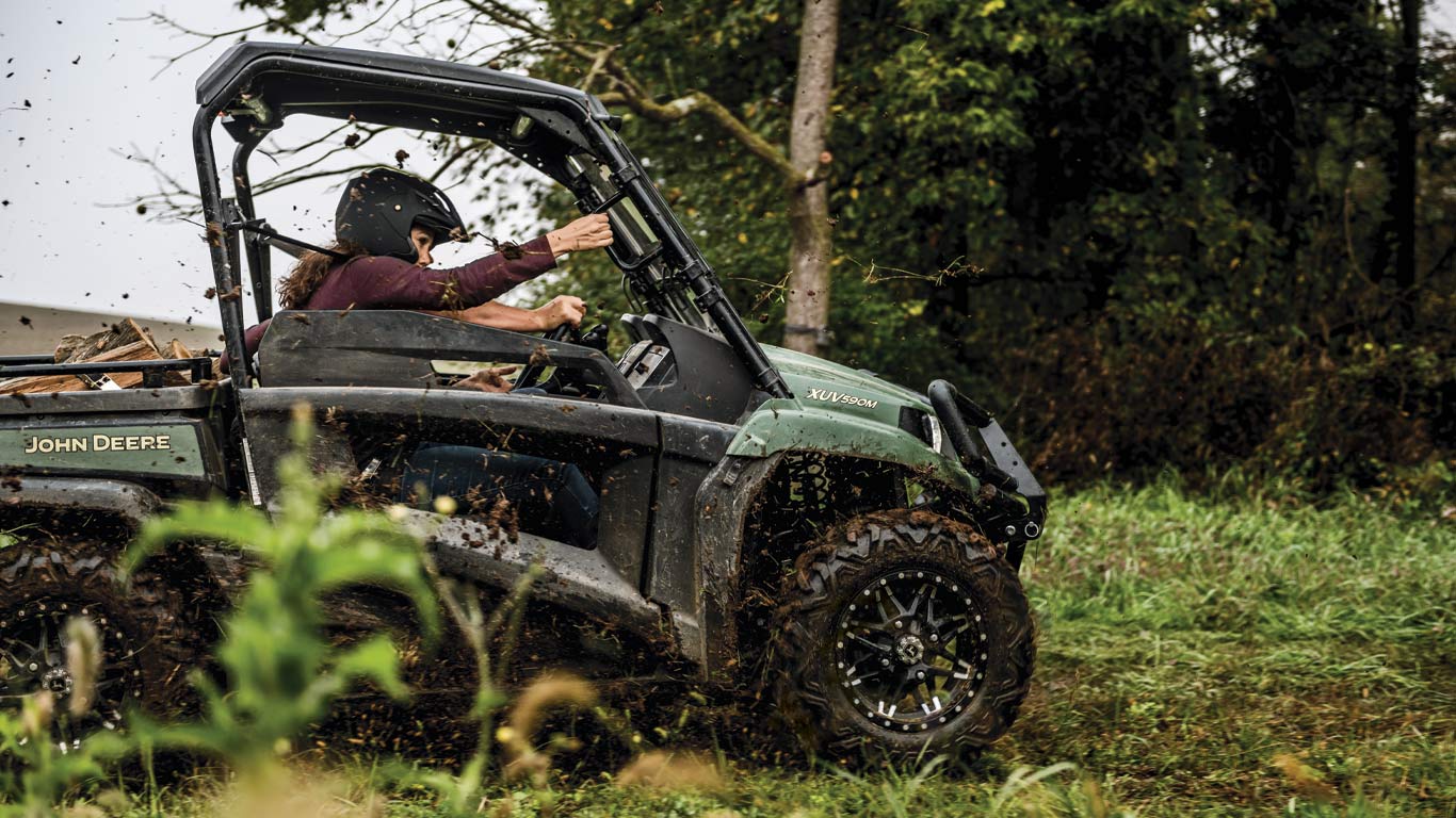 mid-size gator™ being driven on a dirt trail