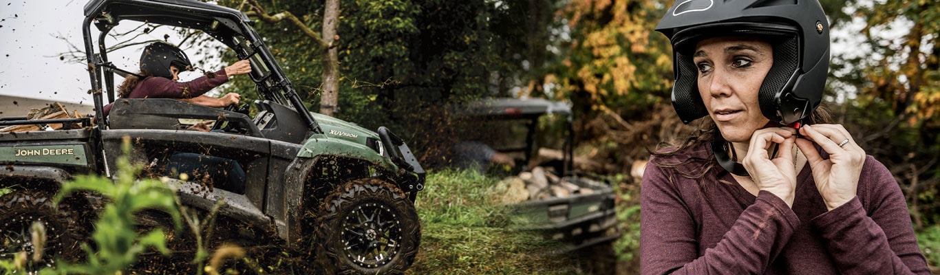 Woman putting on helmet to ride in an XUV590M Gator Utility Vehicle