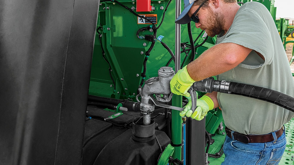 man fueling harvester