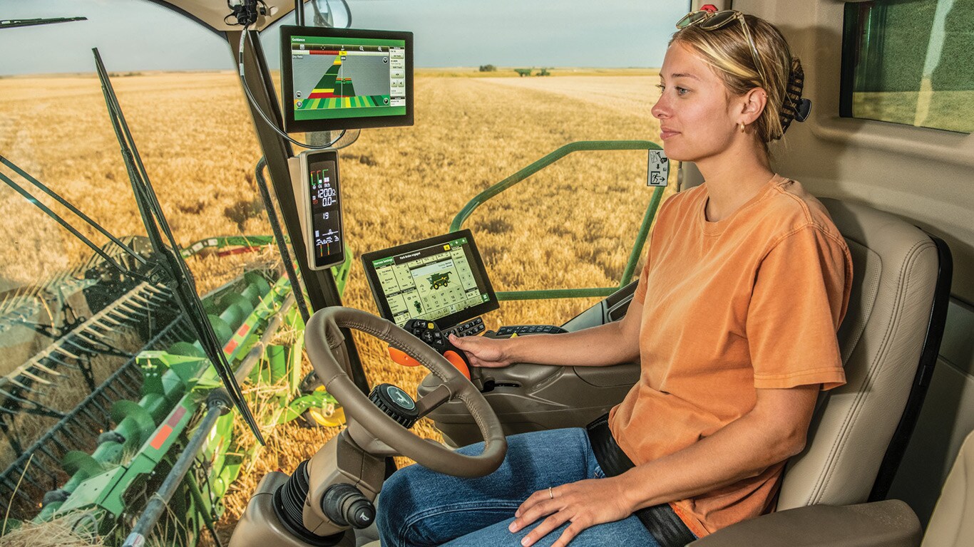 Person in S Series combine cab out in the field