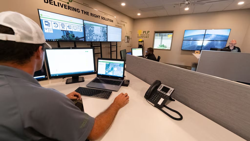 Photo showing a the back of a John Deere specialist in a John&nbsp;Deere Connected Support Center.