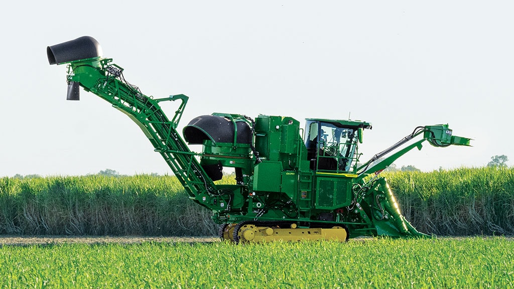 Wide photo showing a CH Series Sugar Harvester at work in a sugar cane field.